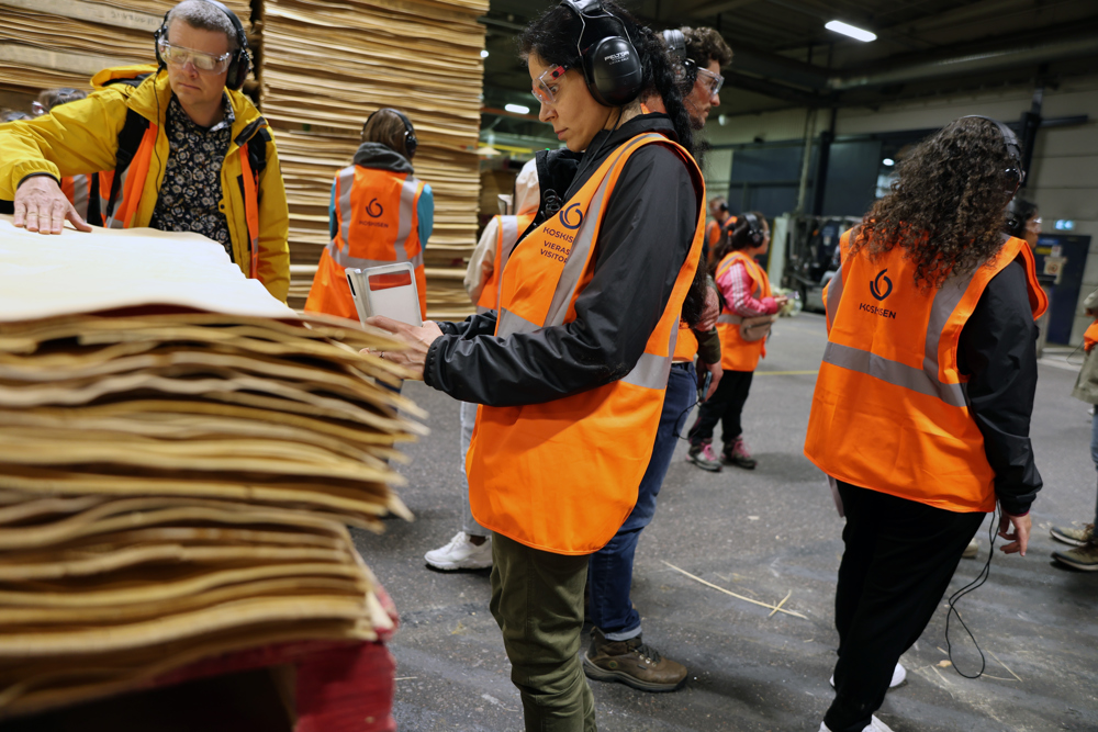 Persons looking at plywood stacks in industry. Photo.